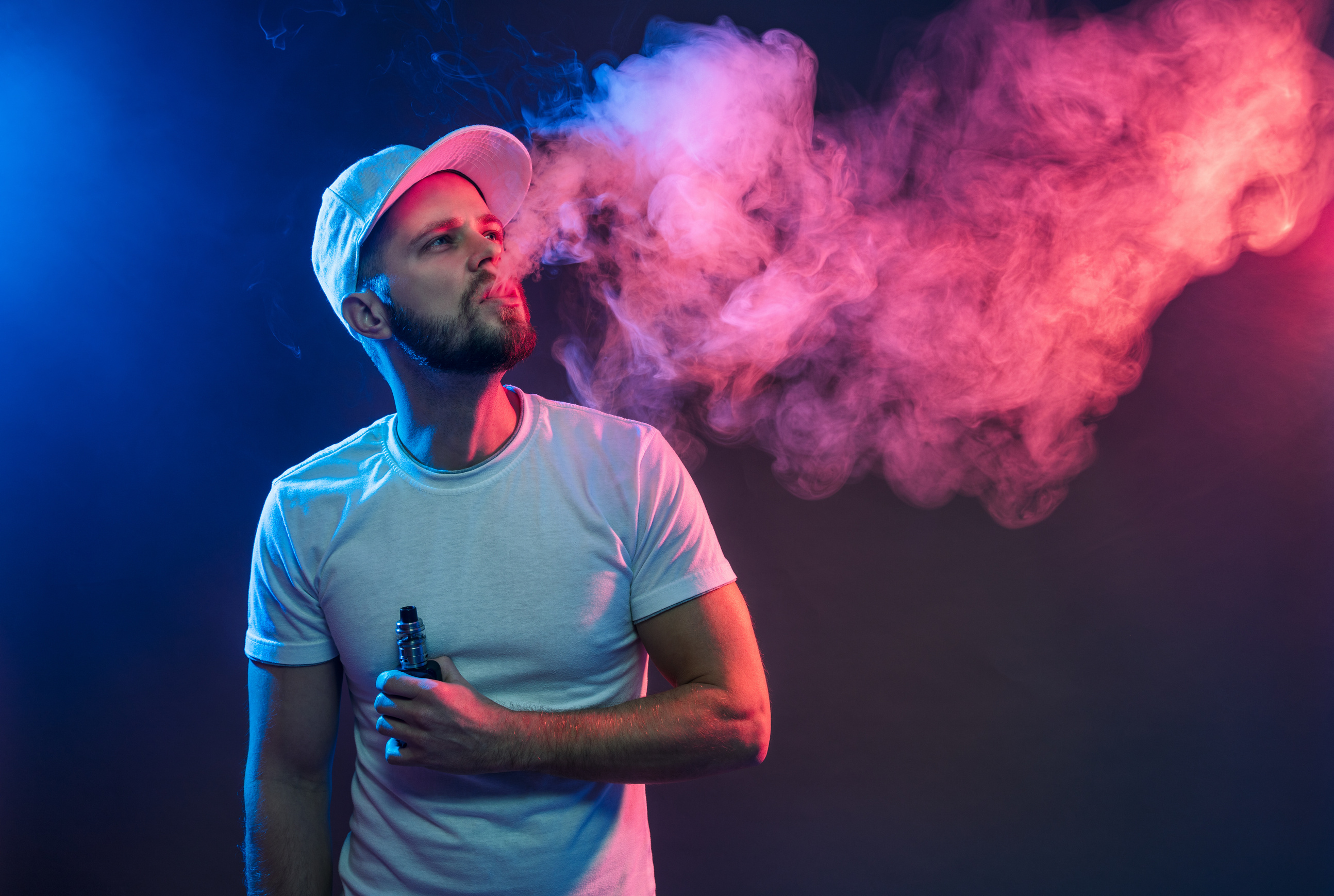 Man Vaping E-Cigarette on Colorful Studio Background